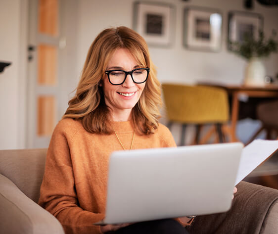 Attractive woman sitting at home and using laptop for work